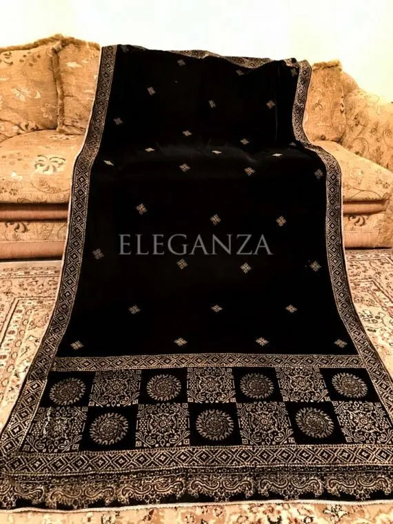 Luxurious velvet shawl featuring bold geometric and circular block prints on the pallu, small geometric motifs in the center, and a delicate golden-threaded border on all sides. ideal for festive occasions or elegant evening wear.