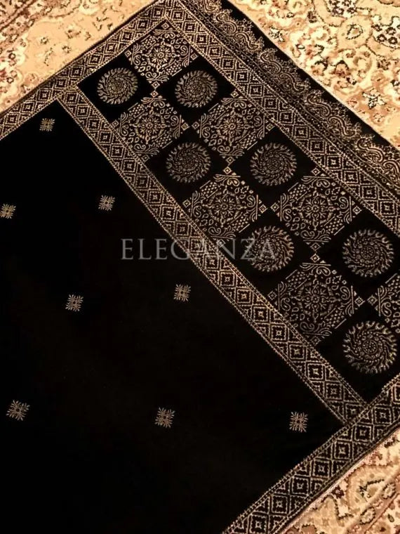 Luxurious velvet shawl featuring bold geometric and circular block prints on the pallu, small geometric motifs in the center, and a delicate golden-threaded border on all sides. ideal for festive occasions or elegant evening wear.