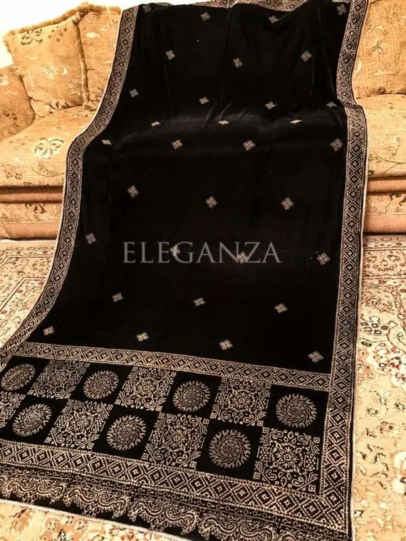 Luxurious velvet shawl featuring bold geometric and circular block prints on the pallu, small geometric motifs in the center, and a delicate golden-threaded border on all sides. ideal for festive occasions or elegant evening wear.