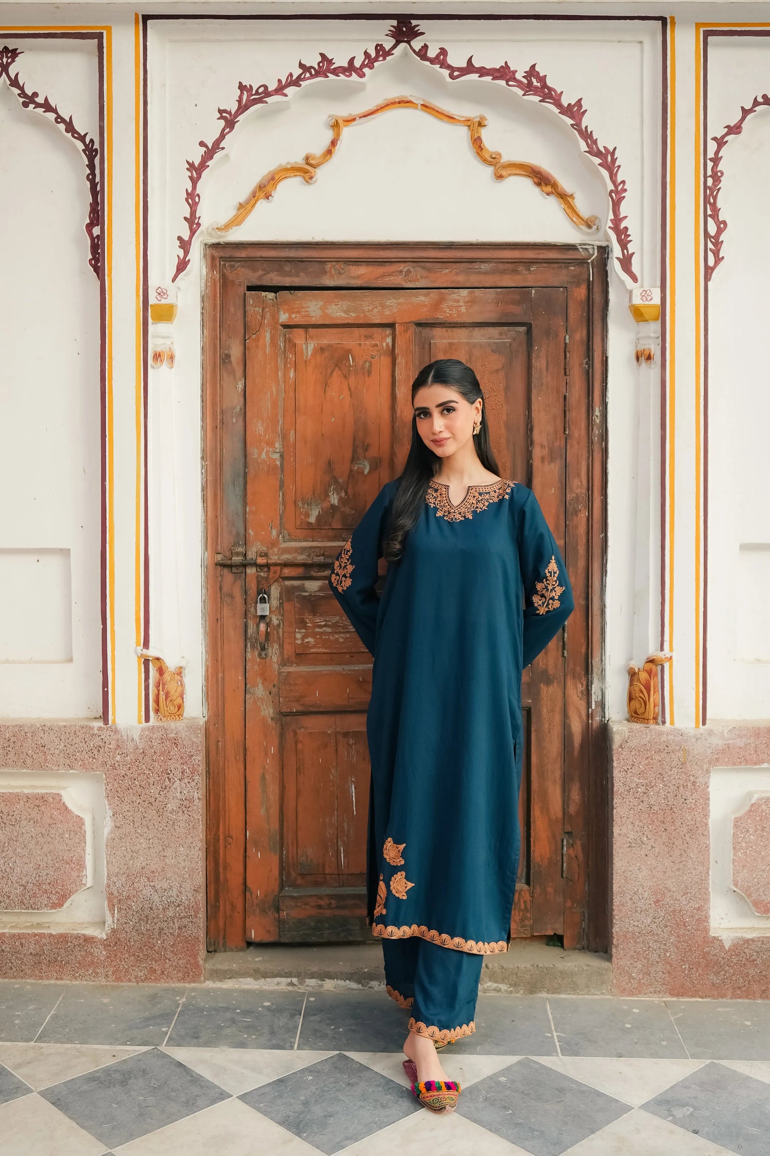 A Zinc blue ensemble featuring delicate light orange embroidery on the neckline, sleeves, and front with fine scattered motifs on the side. Soft threadwork paired with a matching shalwar. The outfit has an elegant, refined silhouette suitable for festive and everyday wear.