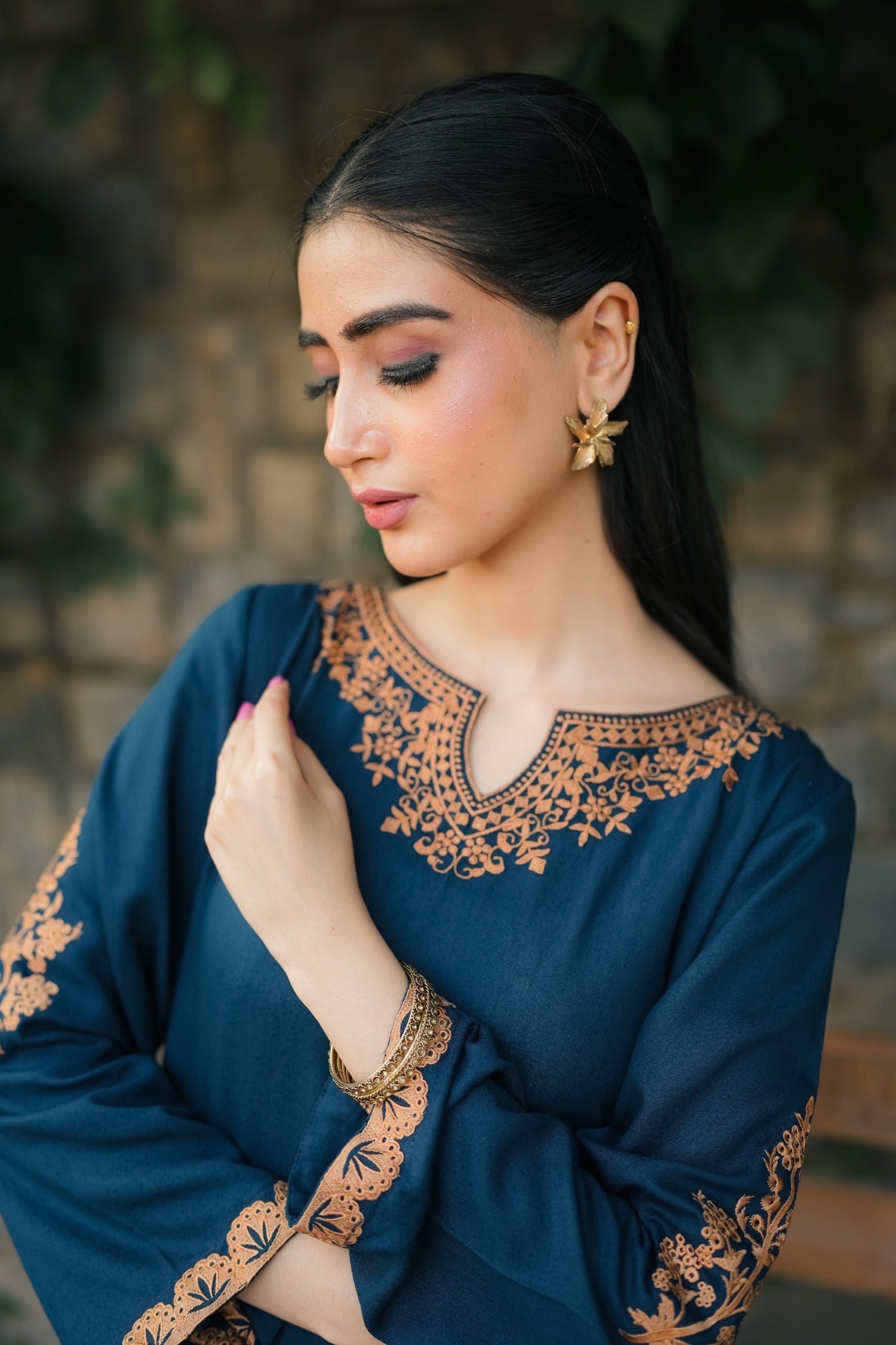 A Zinc blue ensemble featuring delicate light orange embroidery on the neckline, sleeves, and front with fine scattered motifs on the side. Soft threadwork paired with a matching shalwar. The outfit has an elegant, refined silhouette suitable for festive and everyday wear.