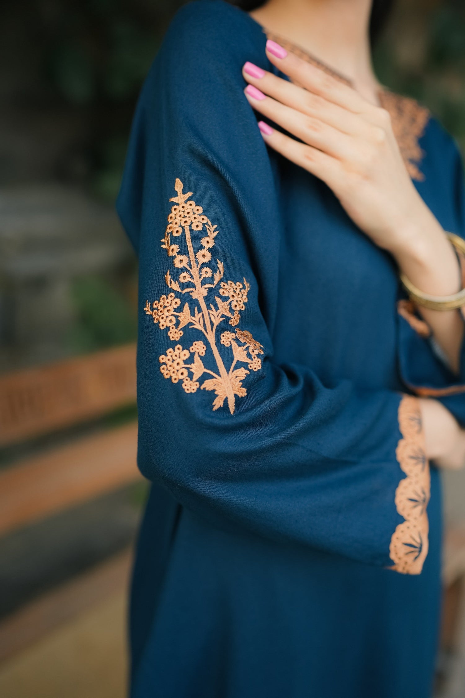A Zinc blue ensemble featuring delicate light orange embroidery on the neckline, sleeves, and front with fine scattered motifs on the side. Soft threadwork paired with a matching shalwar. The outfit has an elegant, refined silhouette suitable for festive and everyday wear.
