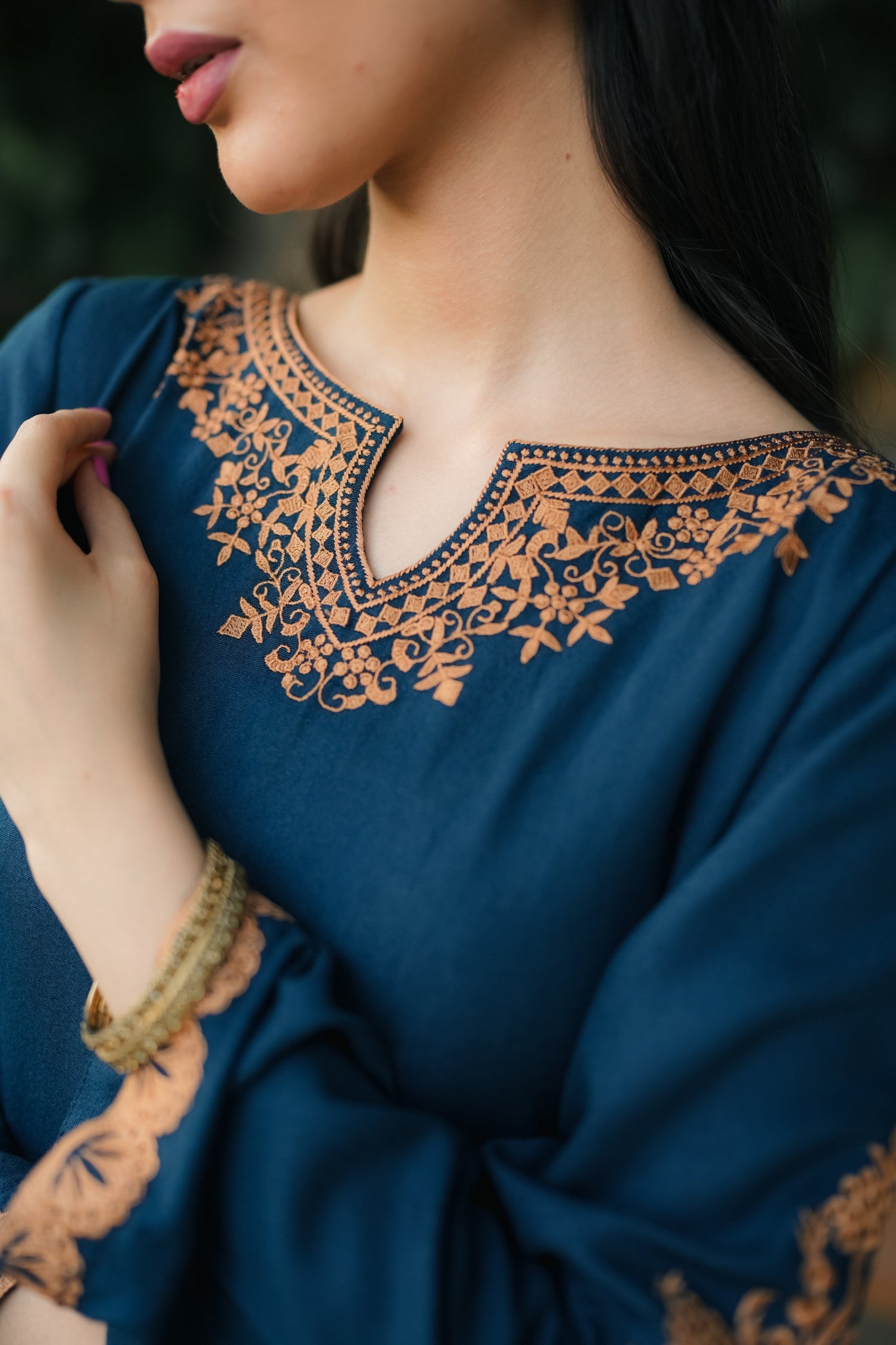 A Zinc blue ensemble featuring delicate light orange embroidery on the neckline, sleeves, and front with fine scattered motifs on the side. Soft threadwork paired with a matching shalwar. The outfit has an elegant, refined silhouette suitable for festive and everyday wear.