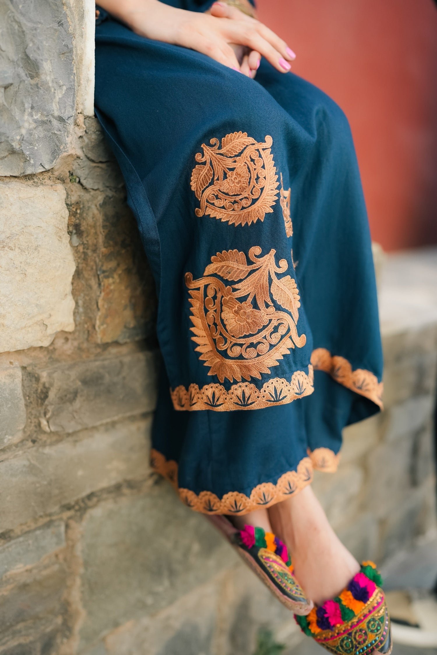 A Zinc blue ensemble featuring delicate light orange embroidery on the neckline, sleeves, and front with fine scattered motifs on the side. Soft threadwork paired with a matching shalwar. The outfit has an elegant, refined silhouette suitable for festive and everyday wear.