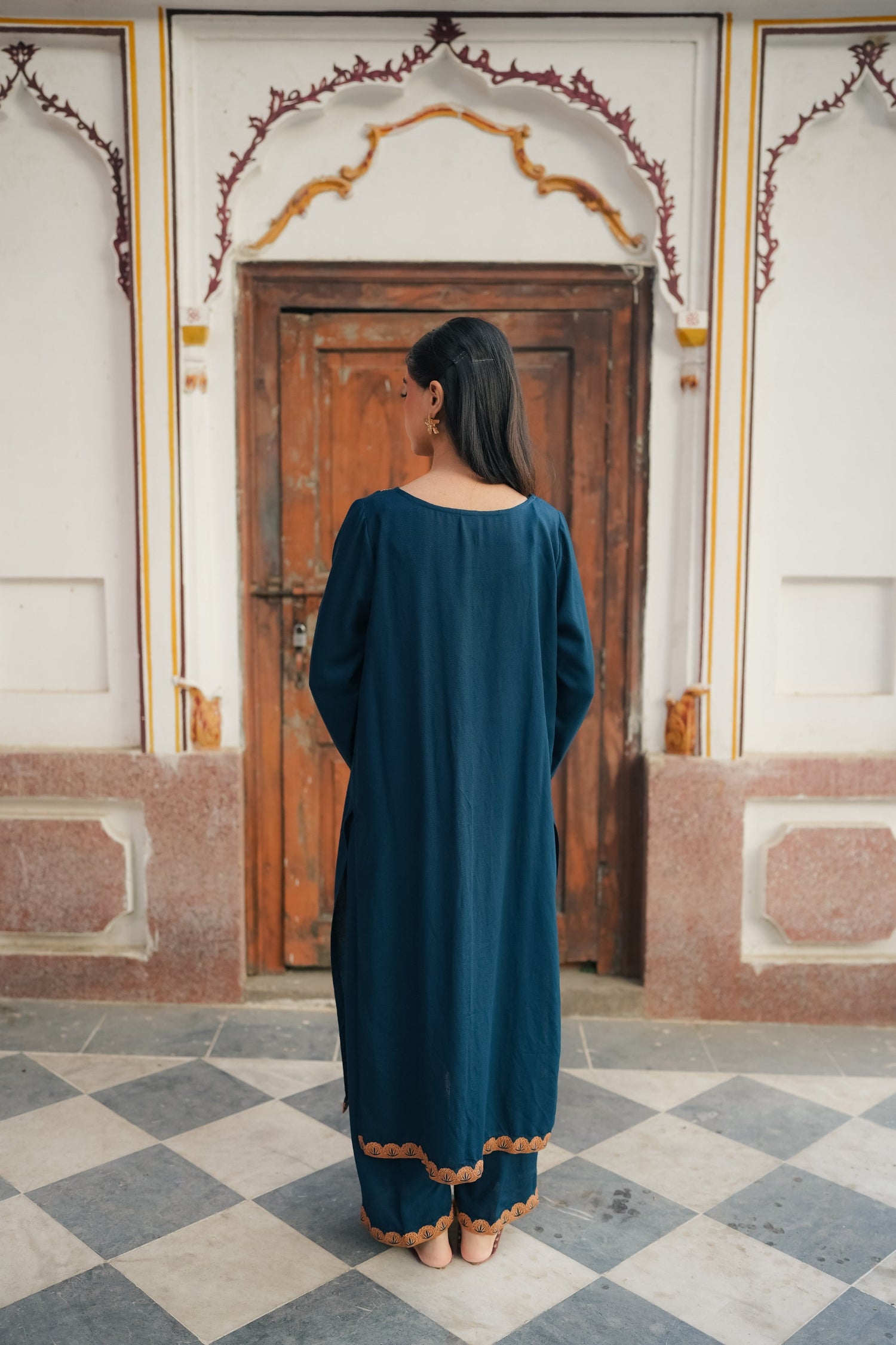 A Zinc blue ensemble featuring delicate light orange embroidery on the neckline, sleeves, and front with fine scattered motifs on the side. Soft threadwork paired with a matching shalwar. The outfit has an elegant, refined silhouette suitable for festive and everyday wear.