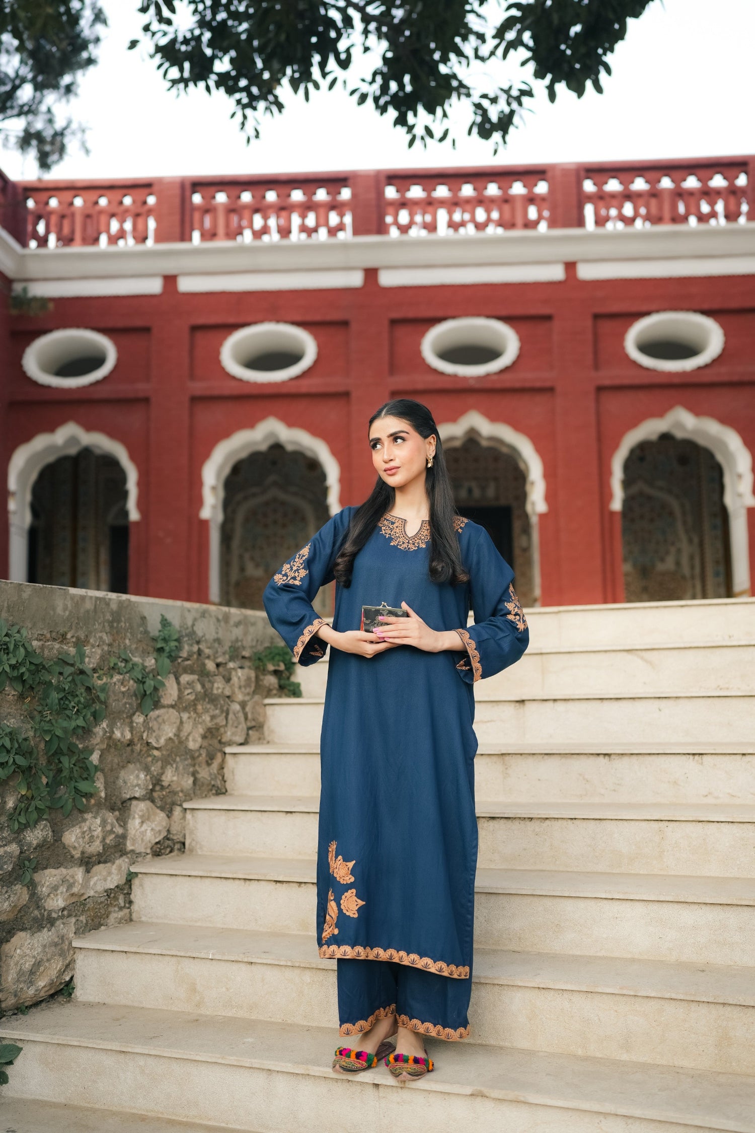 A Zinc blue ensemble featuring delicate light orange embroidery on the neckline, sleeves, and front with fine scattered motifs on the side. Soft threadwork paired with a matching shalwar. The outfit has an elegant, refined silhouette suitable for festive and everyday wear.